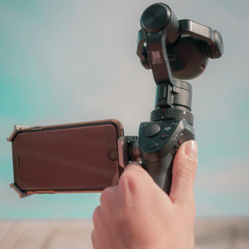 Hand holding a gimbal with smartphone attached, capturing a scene outdoors in Fes, Morocco.