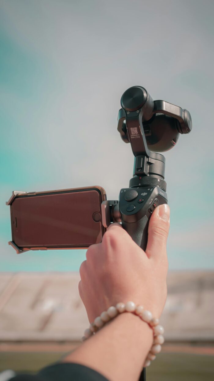 Hand holding a gimbal with smartphone attached, capturing a scene outdoors in Fes, Morocco.
